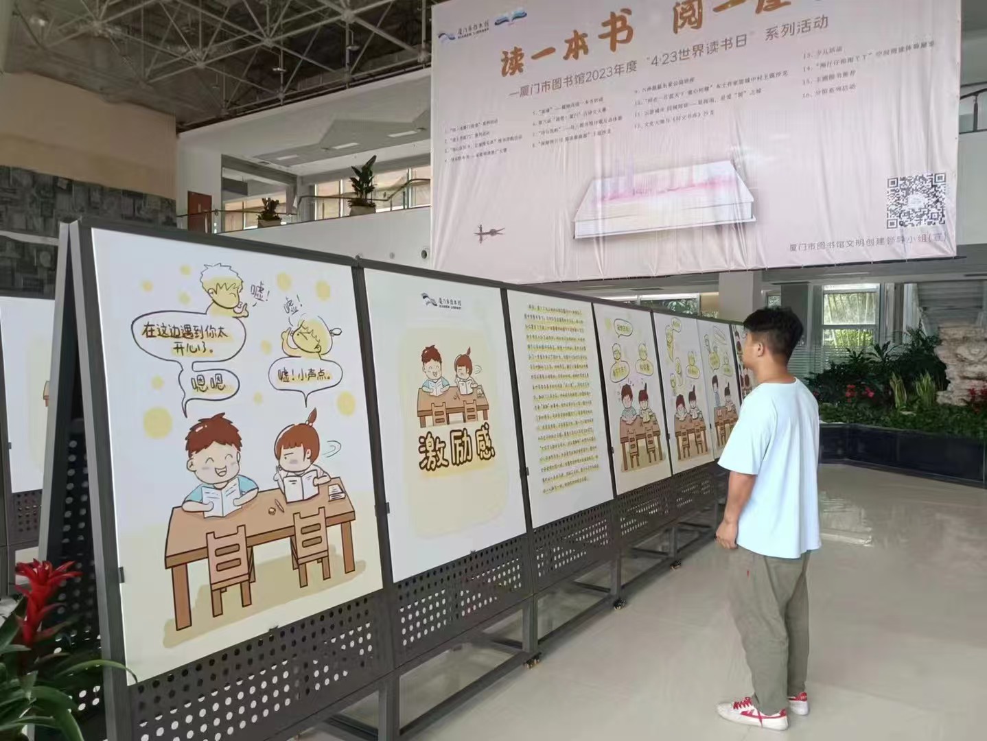 Visitor viewing comics panels under a library event banner
