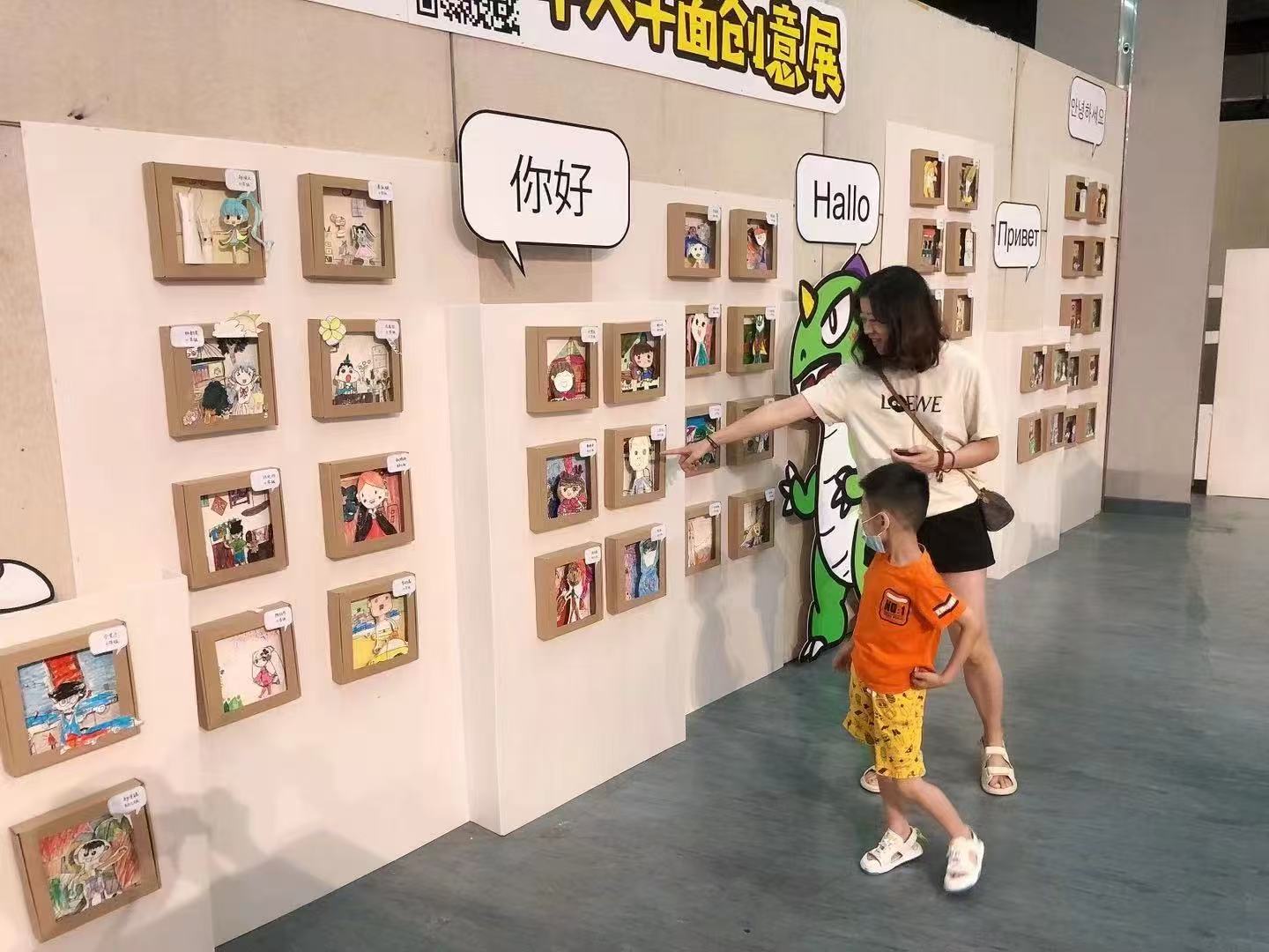 Visitors looking at student artworks on the exhibition wall