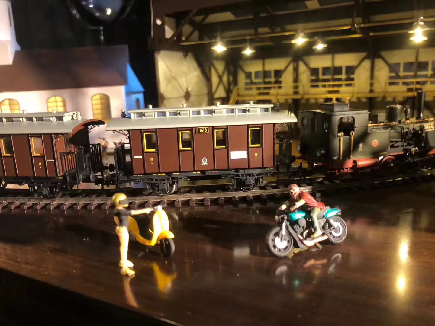 Miniature train scene with tiny figures and warm lights